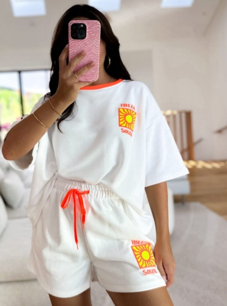 Weißes Boho-Luxe Set aus Baumwolle mit gelbem Sonnen-Print und orangefarbenen Akzenten.