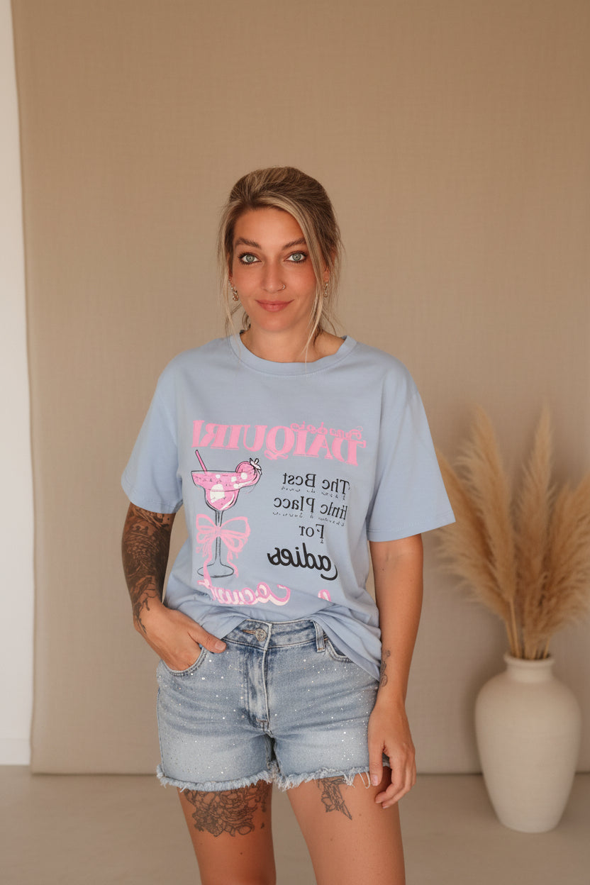 Boho-Luxe Look: Hellblaues Baumwoll-T-Shirt mit Print und hellblaue Denim-Shorts.