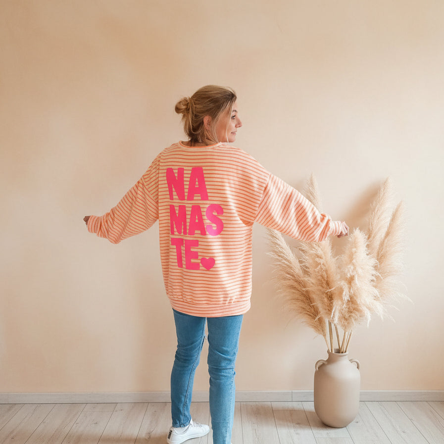 Rückansicht eines Damen-Sweatshirts in Peach-Weiß mit großem NAMASTE-Schriftzug und Herz