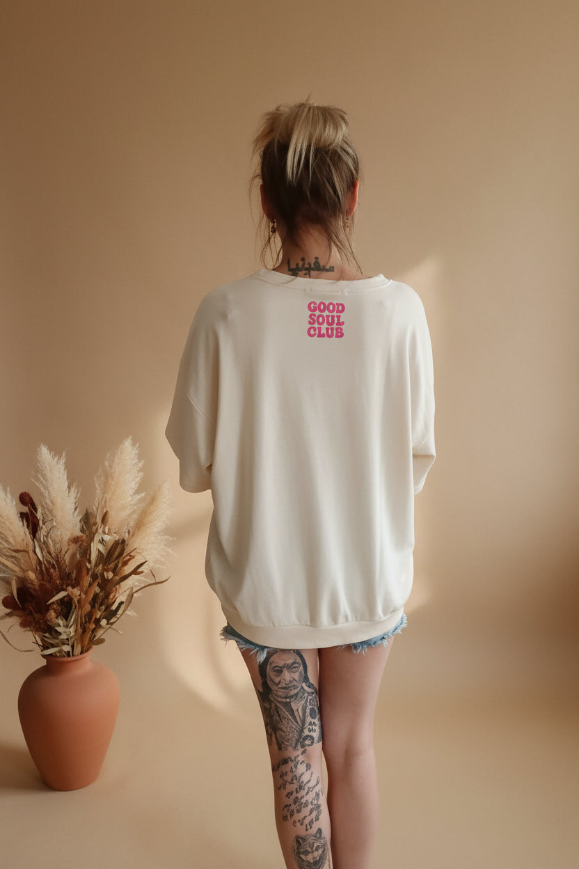 Boho-Luxe cremeweißer Oversize-Sweatshirt mit rotem Print auf dem Rücken.