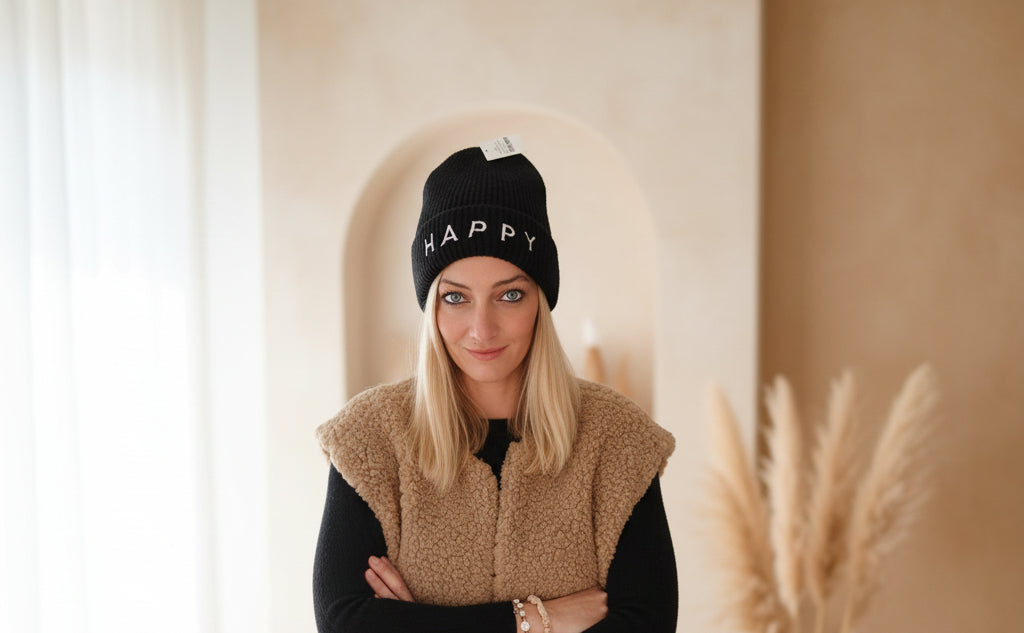 Schwarze Damen-Beanie mit HAPPY-Schriftzug, Seitenansicht im urbanen Winter-Styling