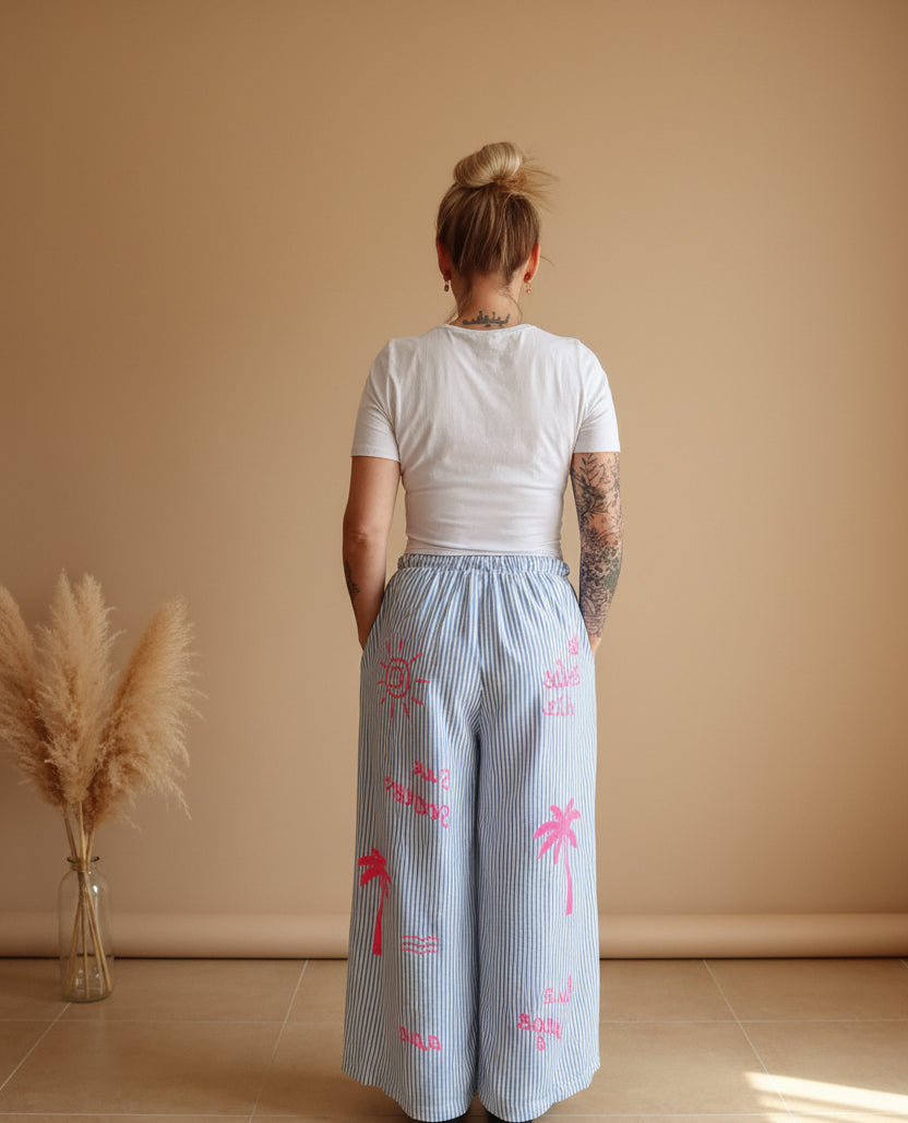 Boho-Luxe hellblaue Leinen-Palazzohose mit rosa Palmen-Print für Damen.