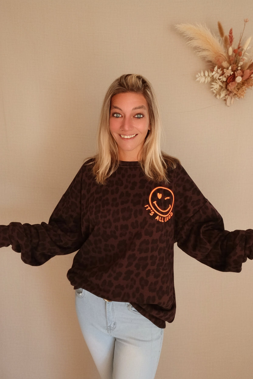 Oversized Sweater It's All Good – Frontansicht Arme ausgebreitet, Sonnenlicht Smiley-Logo sichtbar