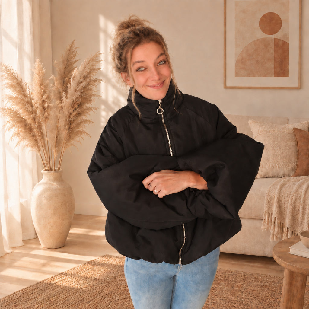 Schwarze Damenjacke mit Stehkragen und weiten Ärmeln, Frontansicht mit verschränkten Armen