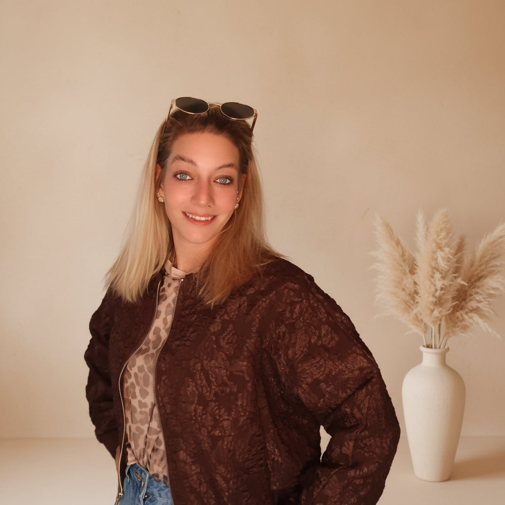 Braune Damen-Bomberjacke mit ornamentalem Muster offen getragen