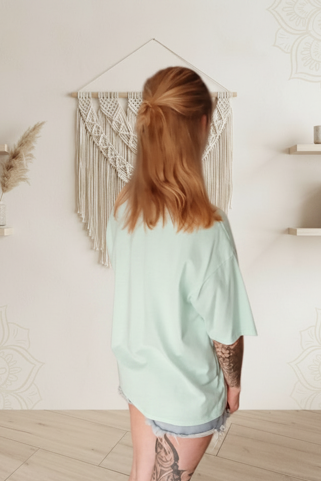 Boho-Luxe Look: Mintgrünes Oversize-T-Shirt aus Baumwolle kombiniert mit hellen Denim-Shorts.