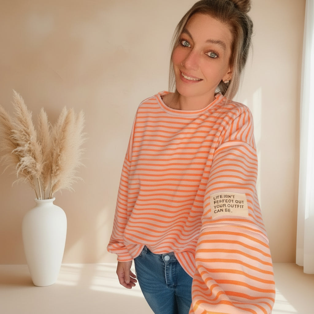 Detailansicht des peachweiß gestreiften Damen Sweatshirts mit kleinem Schriftzug am Ärmel