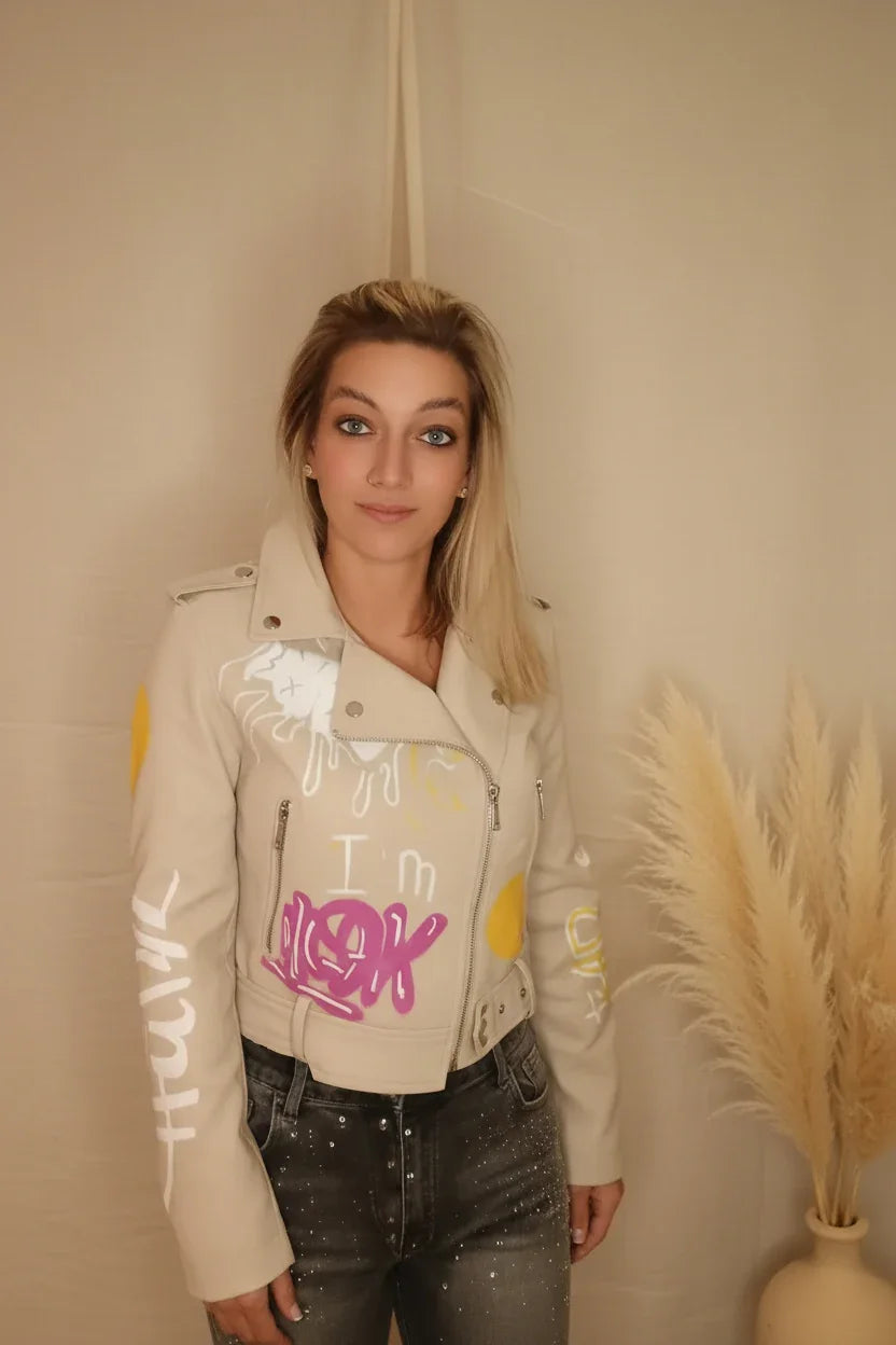 Frau in beigefarbener Lederjacke mit pinken Graffiti-Elementen im Boho-Luxe Stil