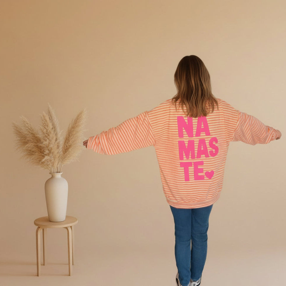 Rückansicht des peach-weiß gestreiften Damen-Sweatshirts mit großem pinkem NAMASTE-Print