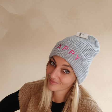 Hellblaue Damen-Strickmütze HAPPY mit rotem Schriftzug, Nahaufnahme von Krempe und Strick