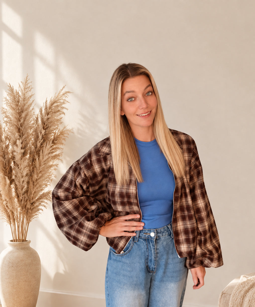 Kurze karierte Damenjacke in Dunkelbraun und Beige, offen getragen, Model mit einer Hand an der Hüfte.