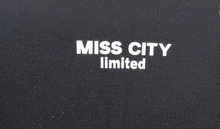 Weißer Aufdruck MISS CITY limited auf schwarzem Stoff im Boho-Luxe Stil.