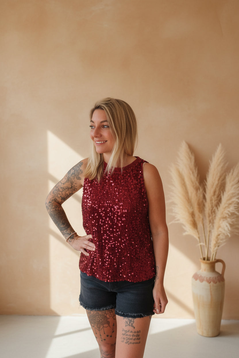 Glamour Pailletten-Top Bordeauxrot – Lifestyle-Shot lächelnd mit Denim-Shorts und Pampas