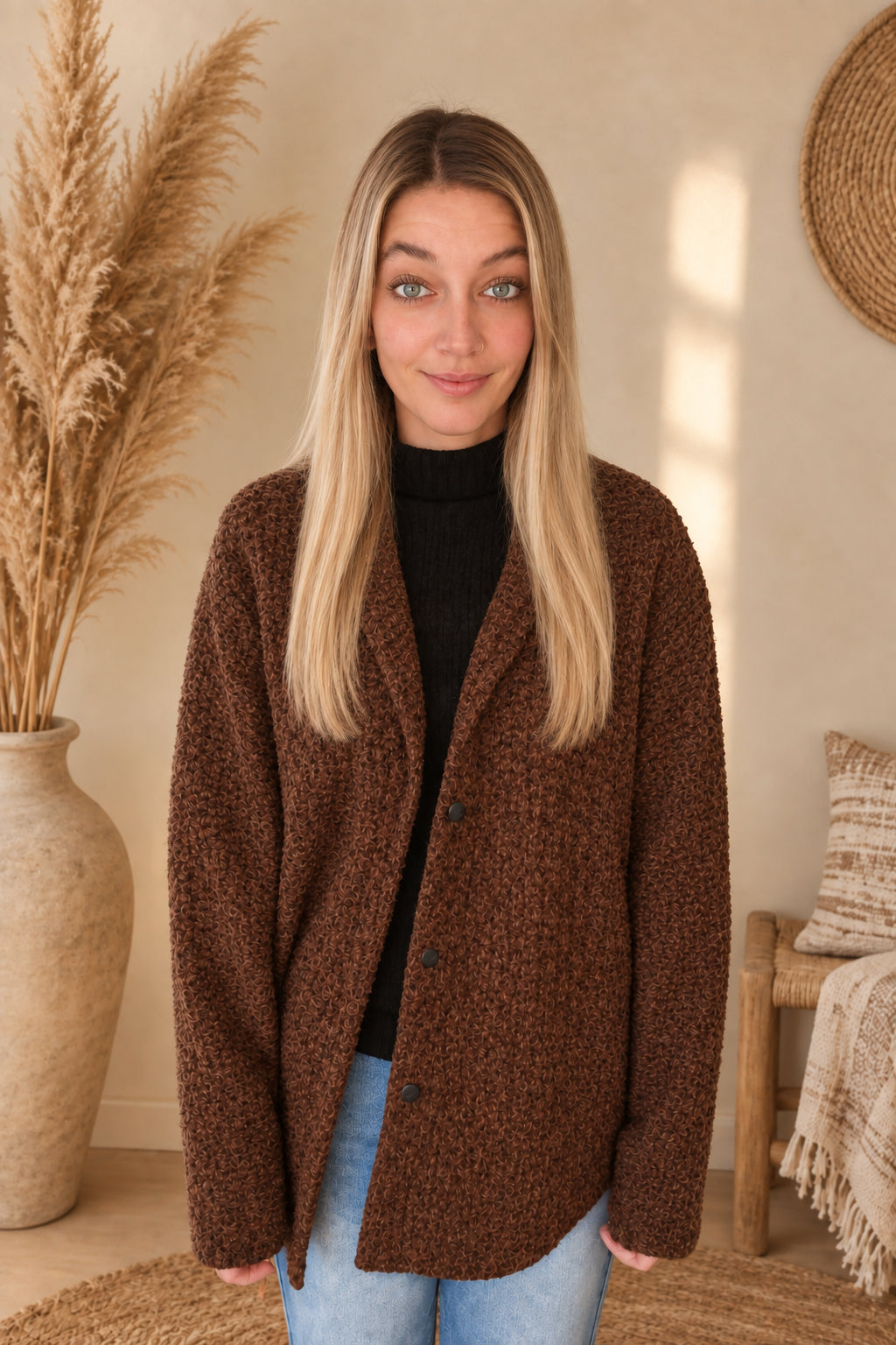 Vorderansicht der braunen Damenjacke mit Kragen und Knopfleiste, offen getragen, am Model mit gesenkten Armen.