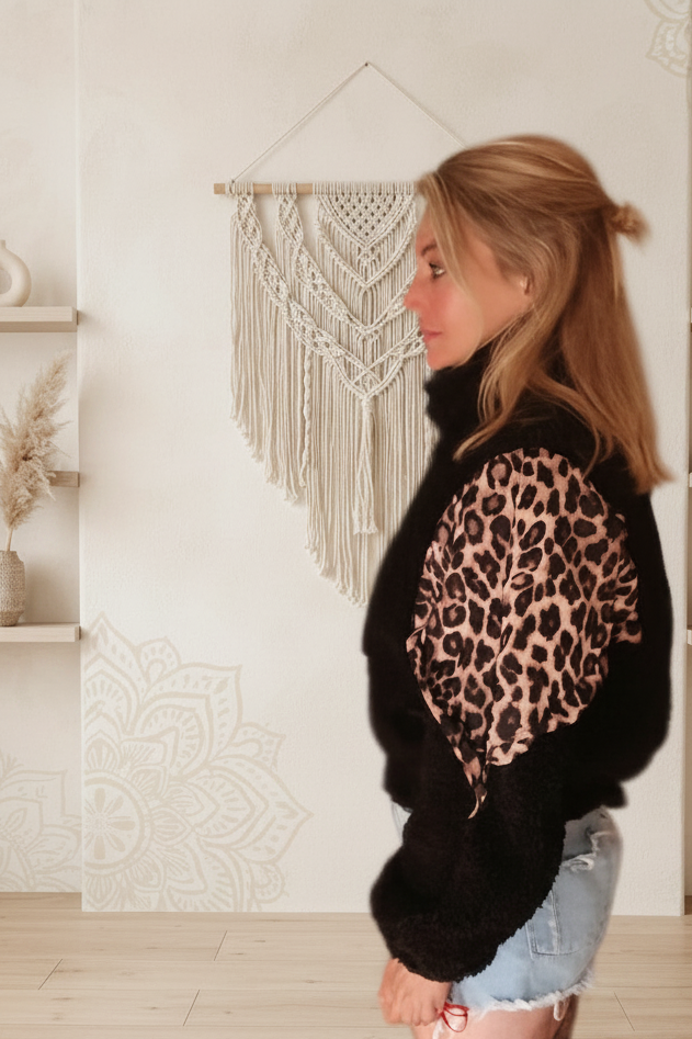 Boho-Luxe Damenmode: Schwarze Kunstpelzjacke mit Leopardenmuster-Einsatz.