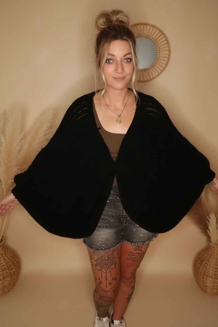 Schwarzer Boho Cardigan Damen – Frontansicht, Modell mit Haardutt, Rattandekor