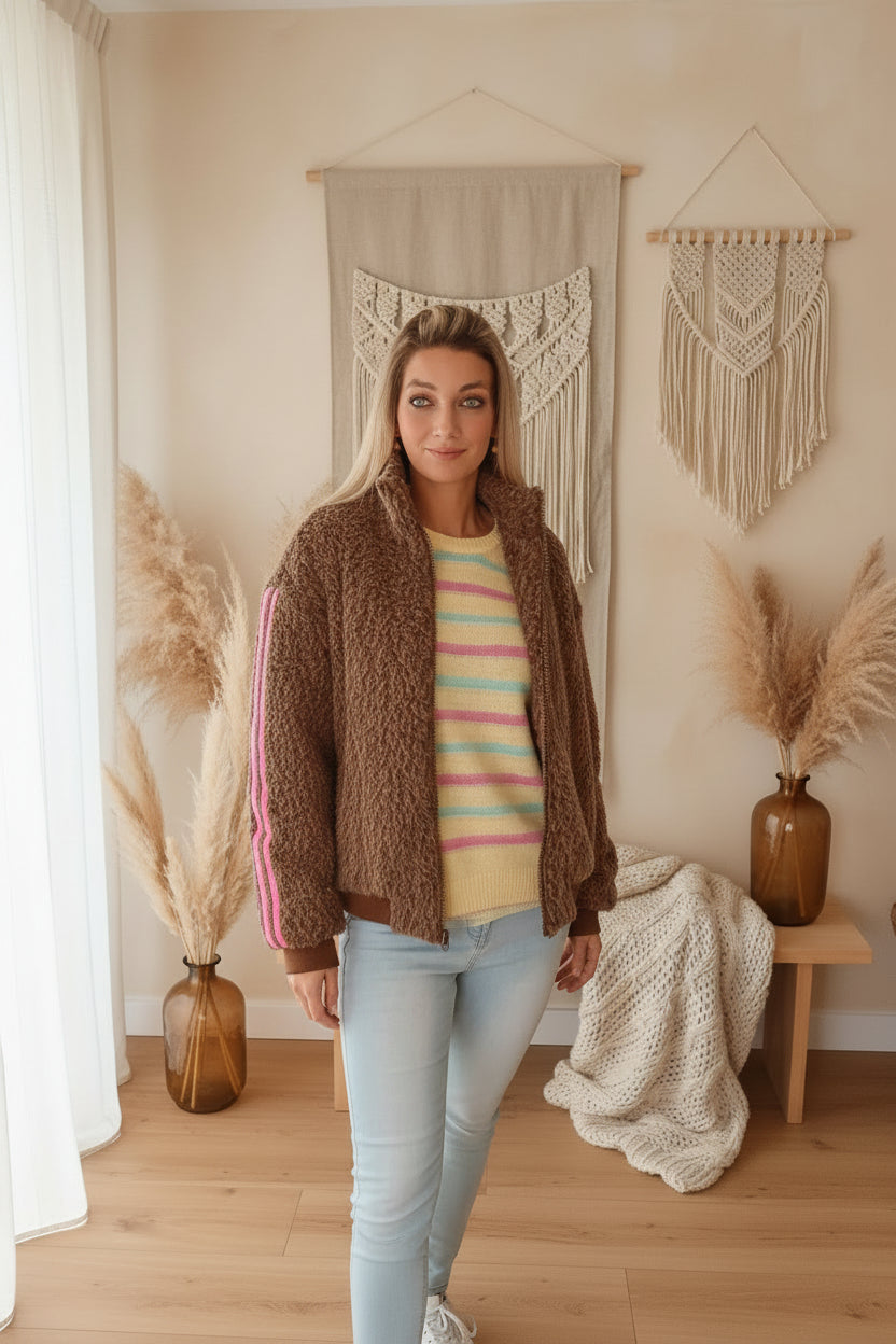 Damen Jacke braun mit pinken Streifen, lässige Pose, natürliches Sonnenlicht
