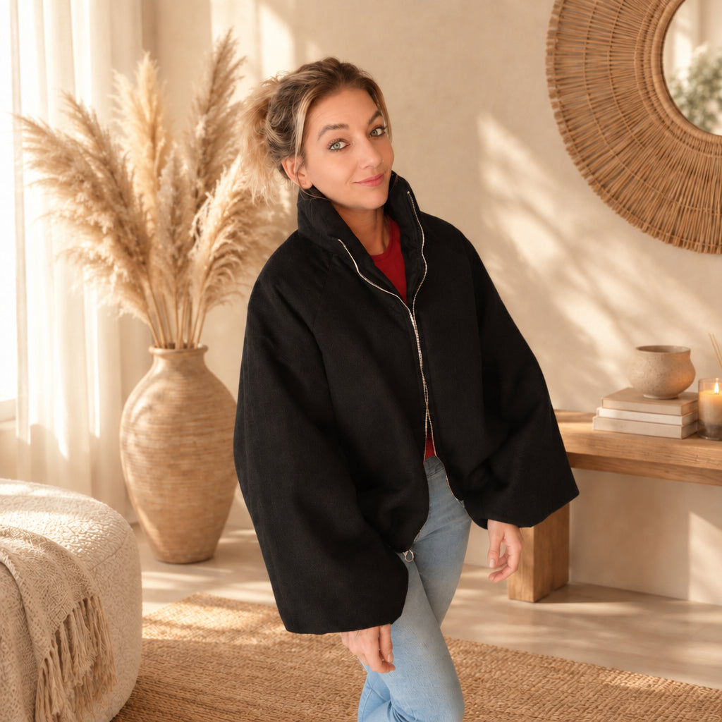 Schwarze Damenjacke mit Stehkragen, seitliche Ansicht zur hellblauen Jeans