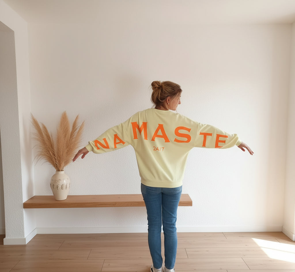Namasté Oversize Sweatshirt Damen Pastellgelb – Rückenansicht Arme ausgestreckt NAMASTE 24/7 Neonorange Großprint heller Raum