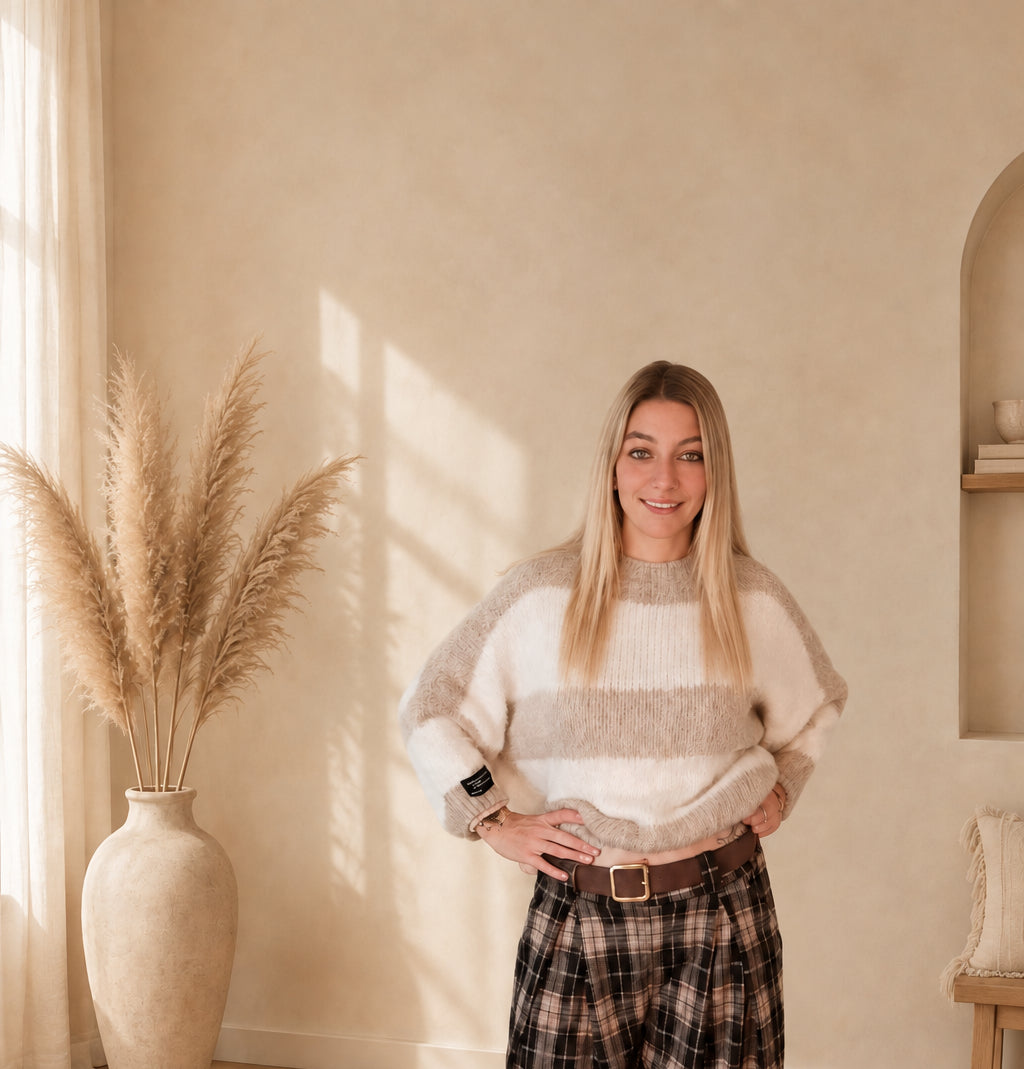 Damen-Strickpullover mit breiten Streifen in Beige und Creme, vorne in den Bund gesteckt und mit kariertem Rock kombiniert