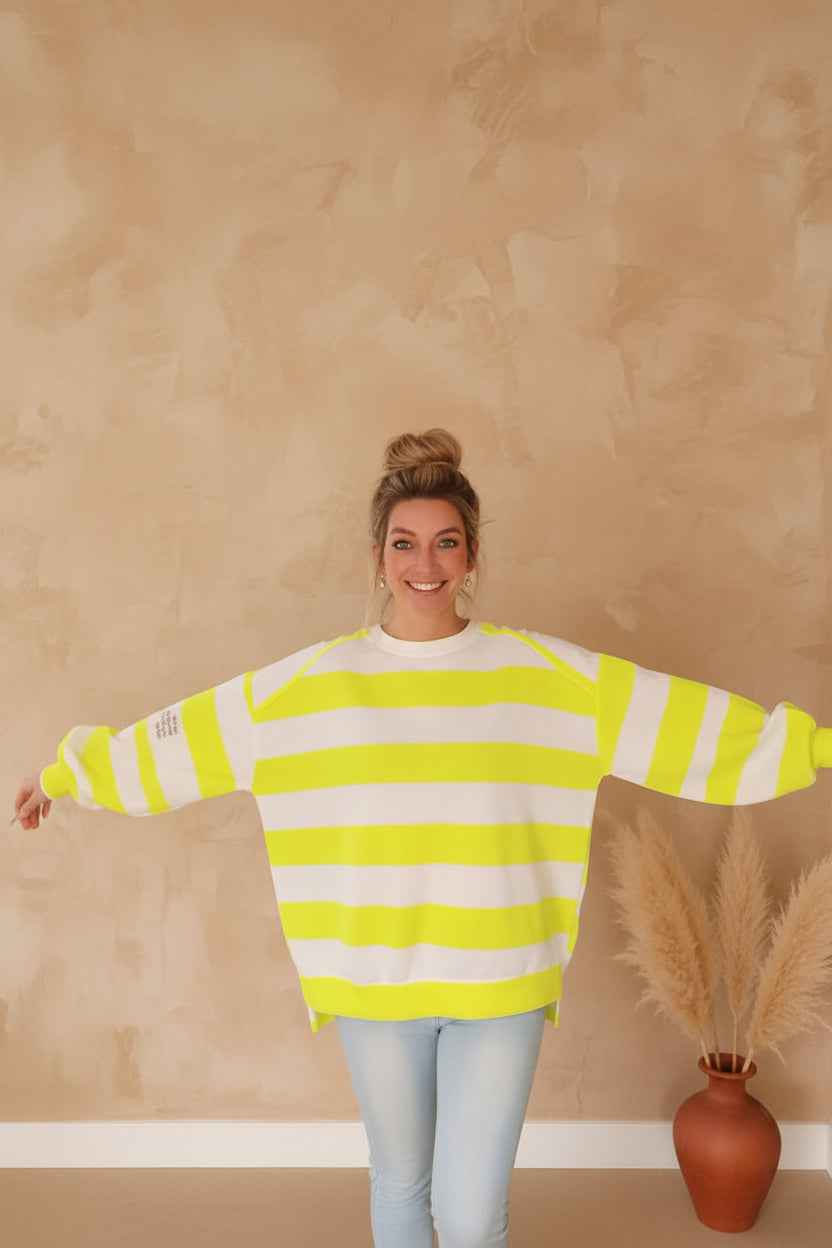 Boho-Luxe Damenmode: Gelb-weiß gestreifter Oversize-Sweatshirt aus weichem Baumwollstoff.
