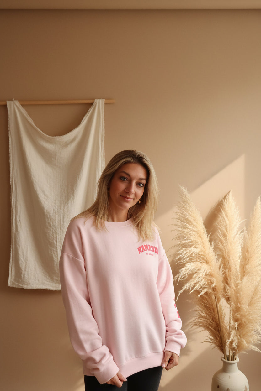 Namasté Oversize Sweater Pink – Frontansicht lächelnd, pinker Namaste-Print, Pampas und weißes Wandtuch
