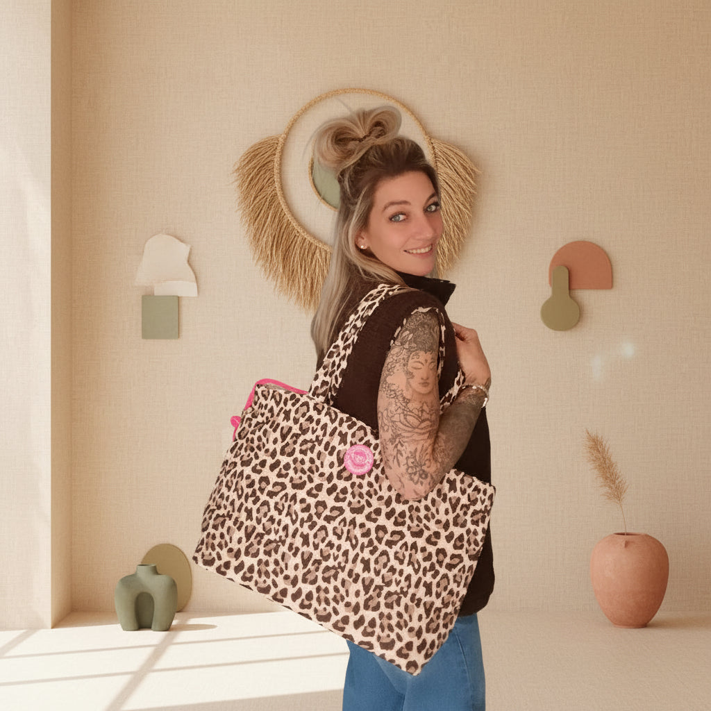 Shopper Leo Allover Beige von Zwillingsherz – hochgehalten vor Boho-Wand mit Macramé und Pampasgras
