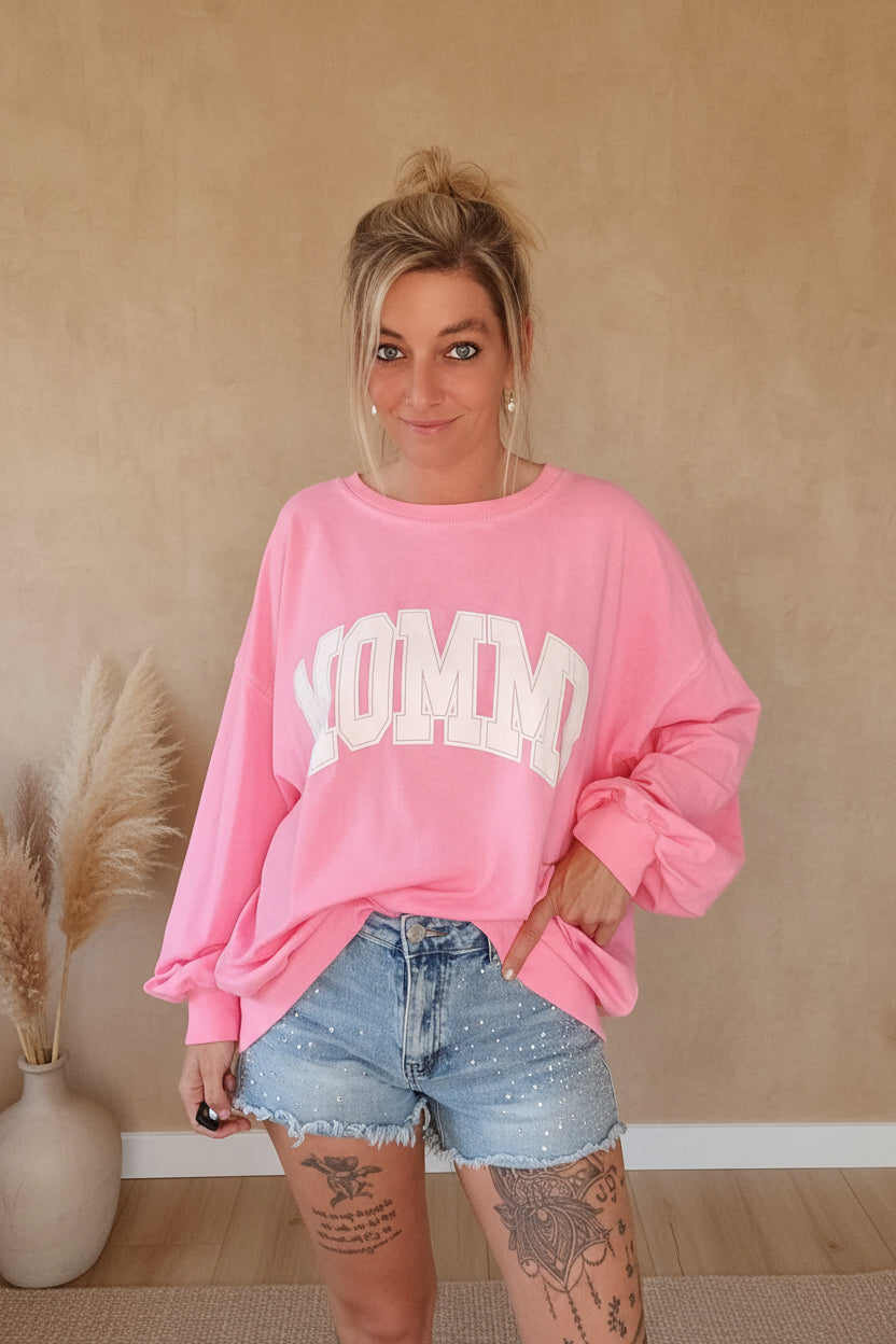 Boho-Luxe Look: Rosa Oversize-Sweatshirt aus Baumwolle kombiniert mit hellblauen Denim-Shorts.