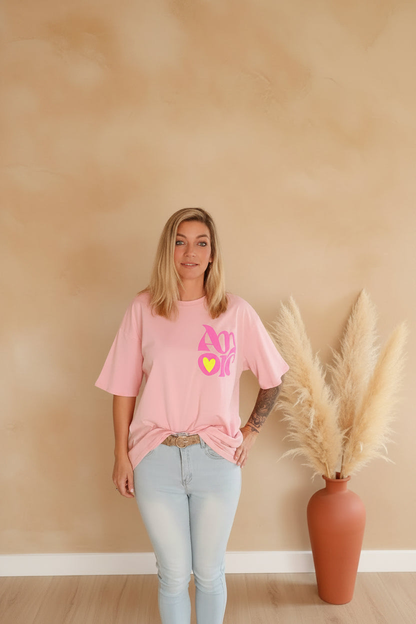 Amore Rosa Oversized T-Shirt rosa – Frontansicht mit Amore-Print, kombiniert mit heller Jeans, Boho-Styling