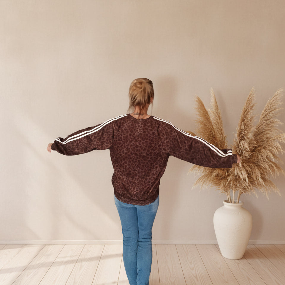 Damen trägt braunes Leo Sweatshirt mit sportlichen weißen Ärmelstreifen