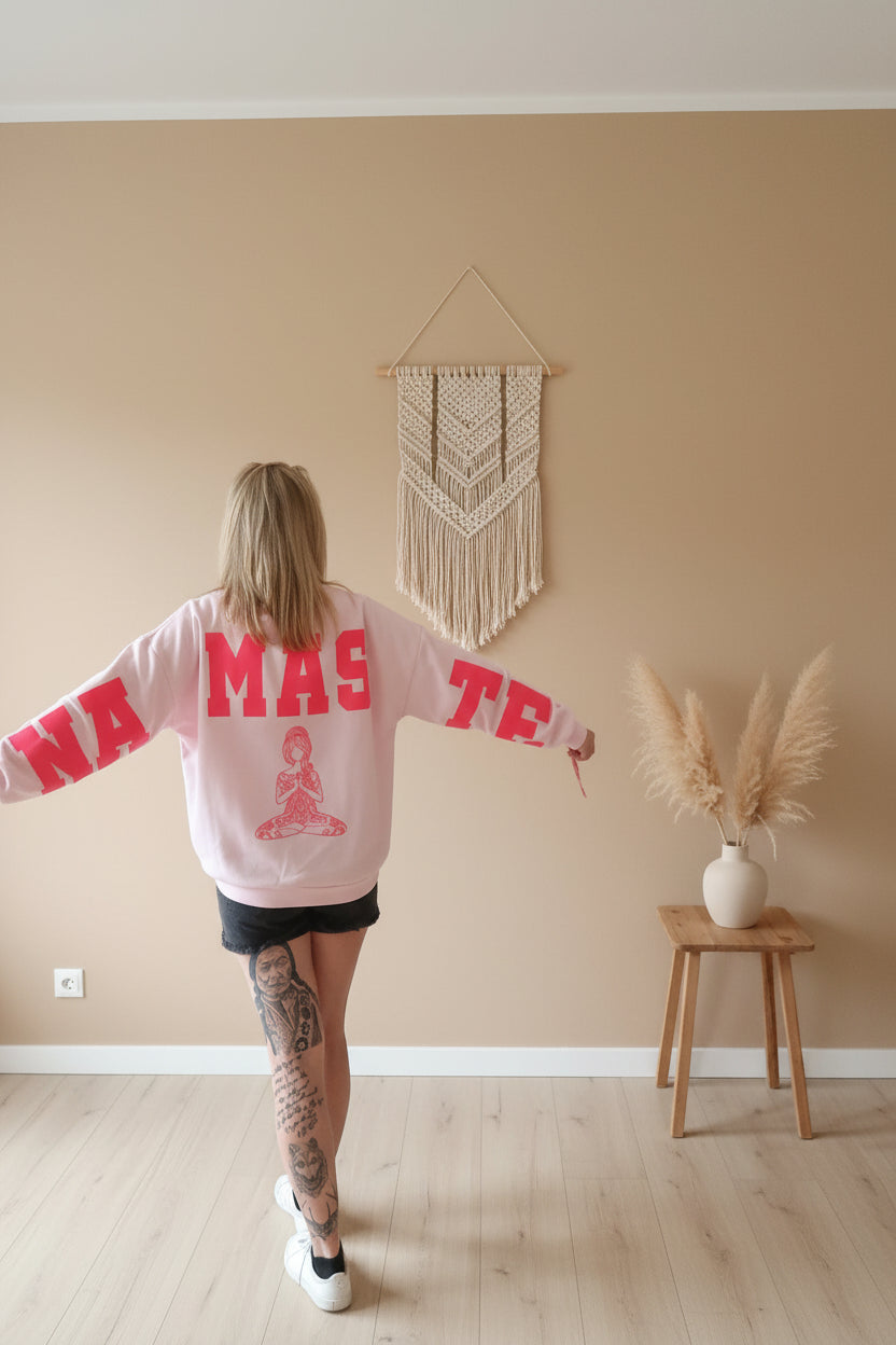 Namasté Oversize Sweater Pink – Rückenansicht mit NAMASTE-Schriftzug über Rücken und Ärmel, Macramé-Deko