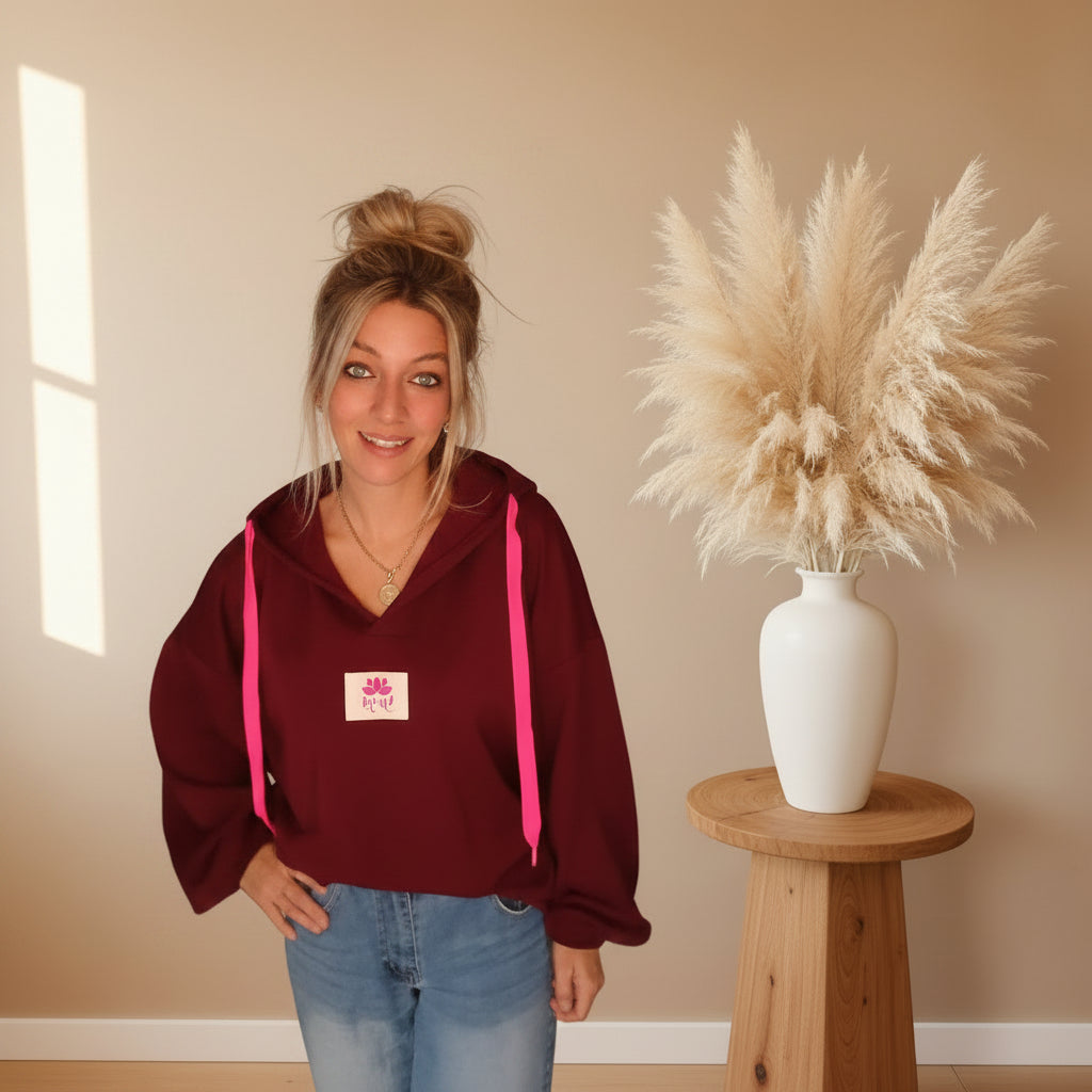 Bordeauxfarbener Yoga-Hoodie mit Kapuze, pinken Kordeln und Yoga-Lotus-Label in der Vorderansicht