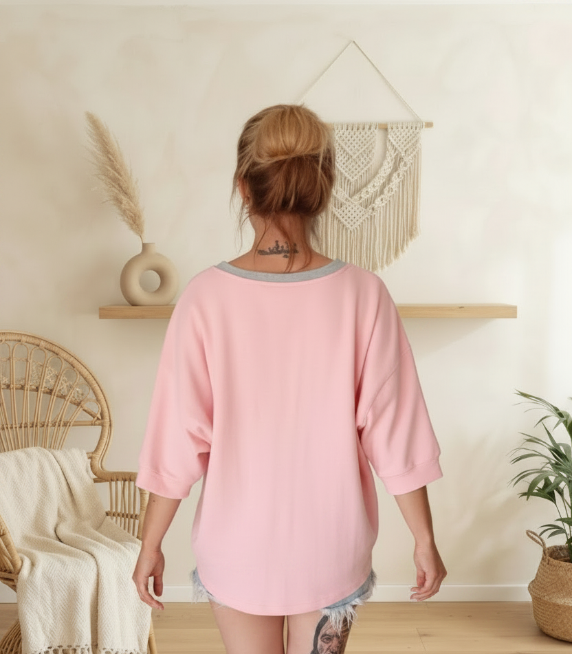 Rückansicht einer Frau in einem oversized pinkfarbenen Boho-Luxe Sweatshirt aus Baumwolle.