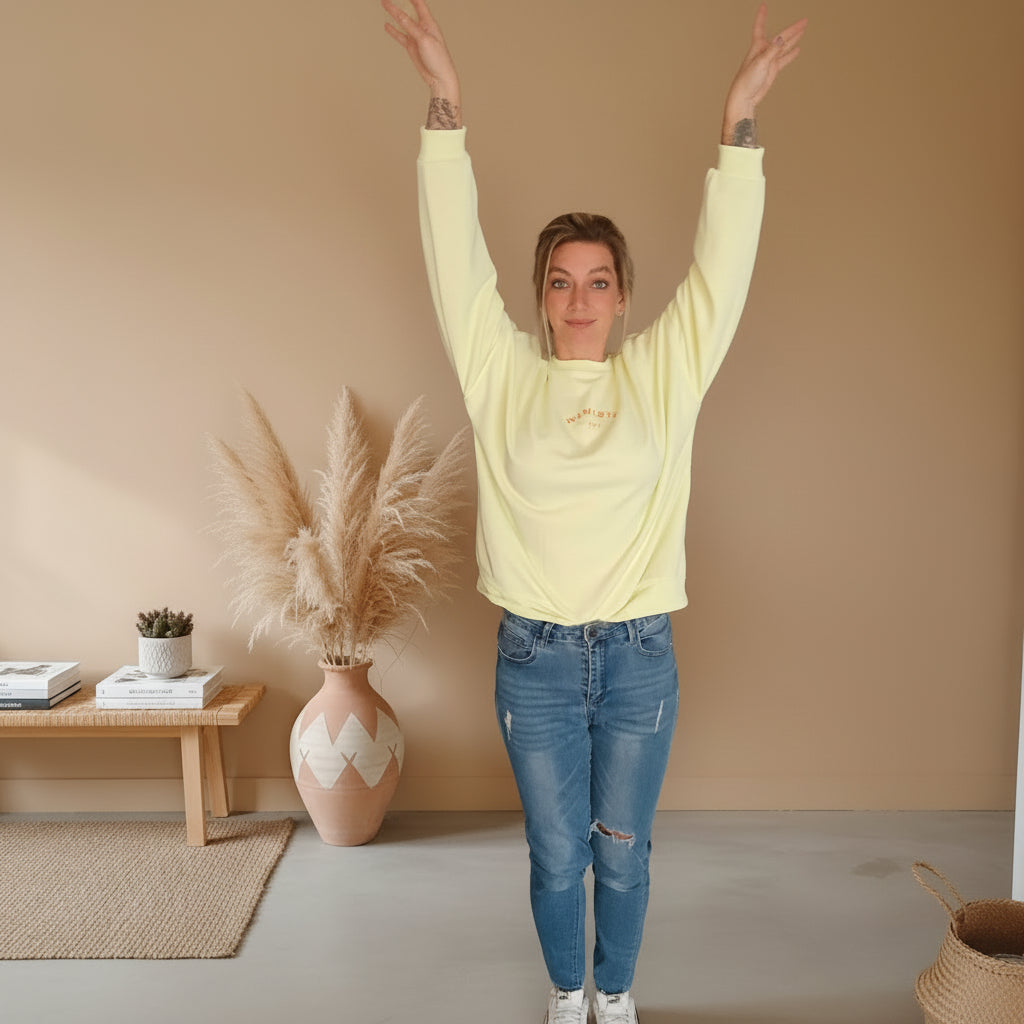 Namasté Oversize Sweatshirt Damen Pastellgelb – Frontansicht Arme hoch gestreckt Boho Wohnzimmer Pampagras Keramikvase
