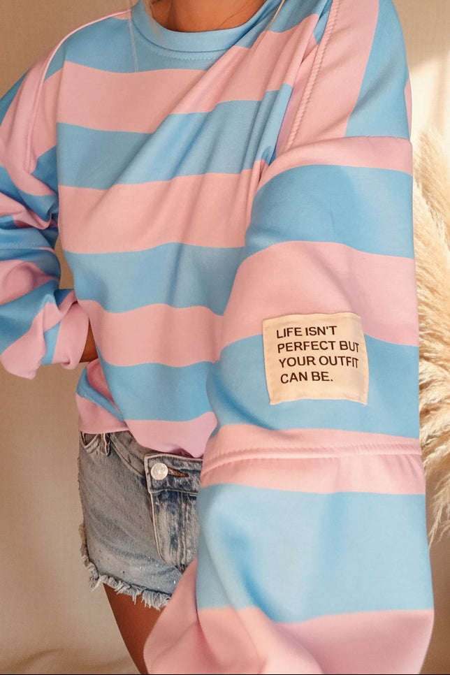 Boho-Luxe Sweatshirt in Blau-Rosa gestreift mit Text-Patch aus weichem Baumwollstoff.