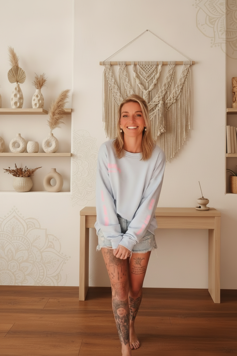 Boho-Luxe Look: Hellblaue Sweatshirt-Kombination mit hellen Denim-Shorts in stilvollem Ambiente.