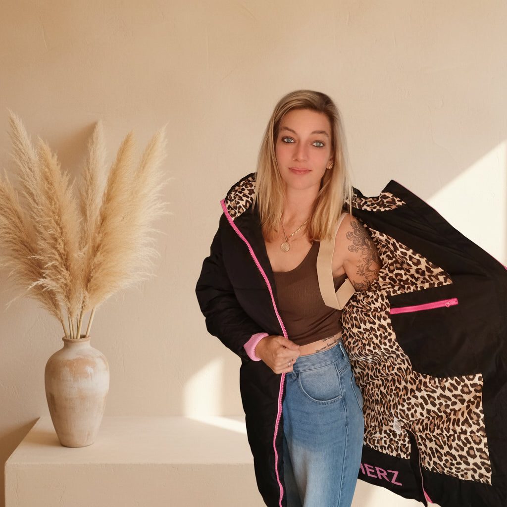 Geöffneter schwarzer Zwillingsherz-Steppmantel mit Leopardenmuster-Innenfutter und pinker Innentasche