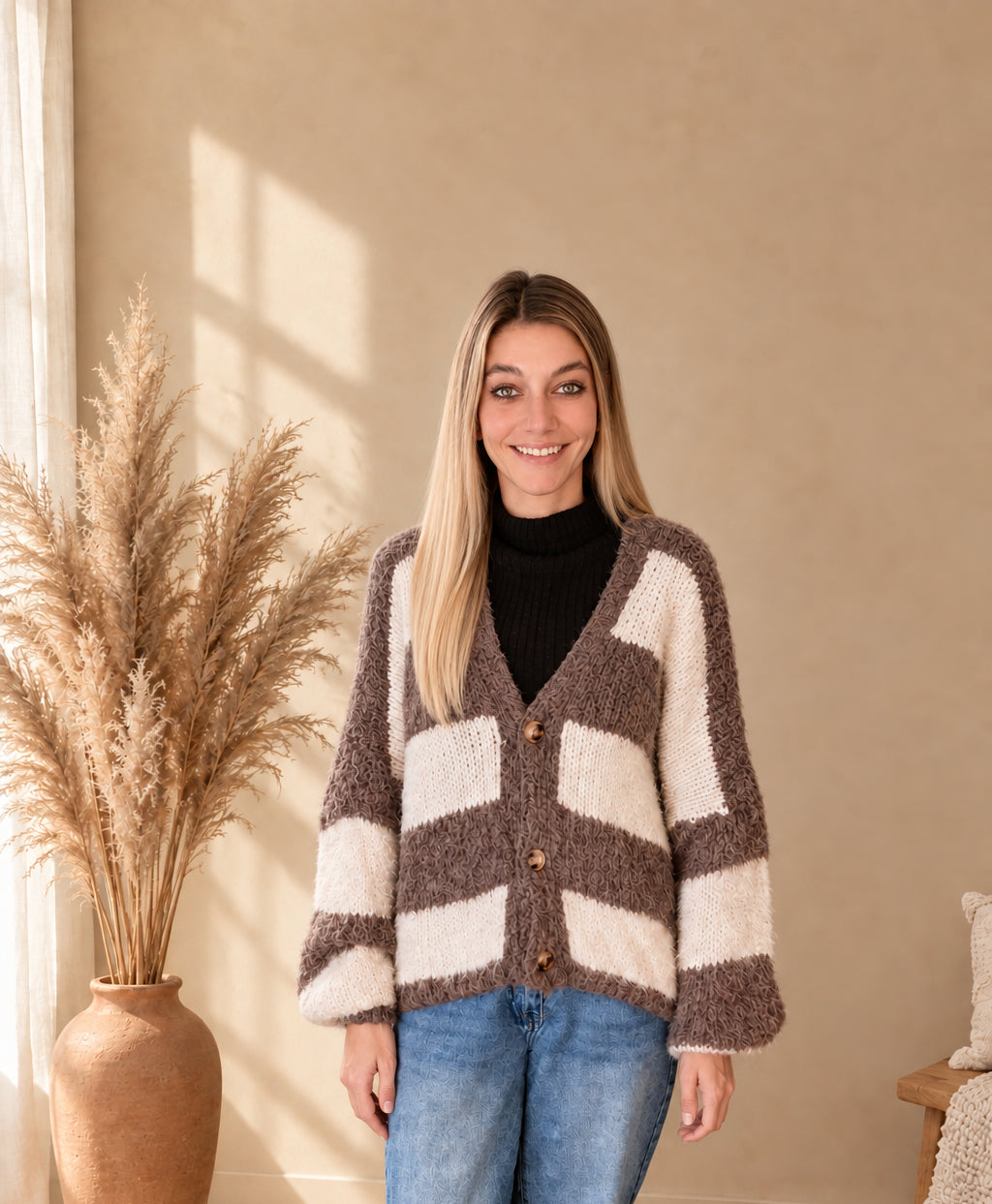 Damen-Strickcardigan mit breiten Streifen in Taupe-Creme, V-Ausschnitt und Knopfleiste, am Model mit gesenkten Armen.