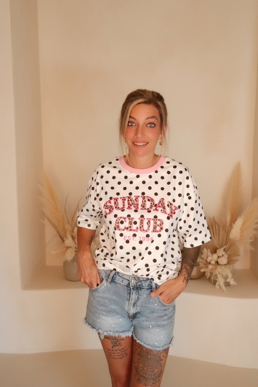 Boho-Luxe Look: Weißes Polka-Dot T-Shirt mit Glitzerprint und hellblaue Denim-Shorts.