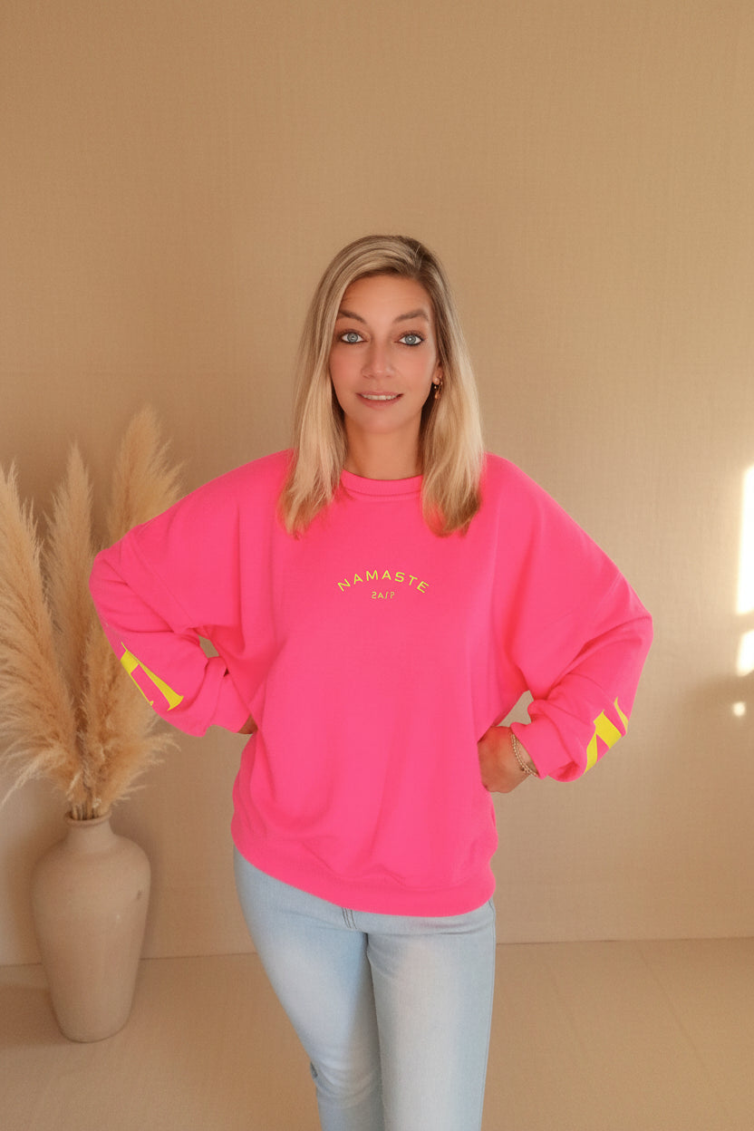 Namaste 24/7 Oversized Sweatshirt Pink – Frontansicht mit goldenem Namaste-Logo, kombiniert mit Jeans

