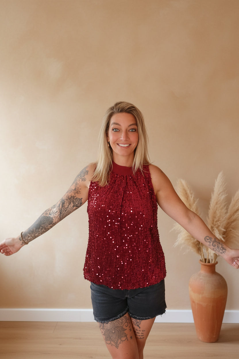 Pailletten-Top Damen Bordeauxrot – Frontansicht lächelnd, Arme ausgebreitet, Boho-Hintergrund