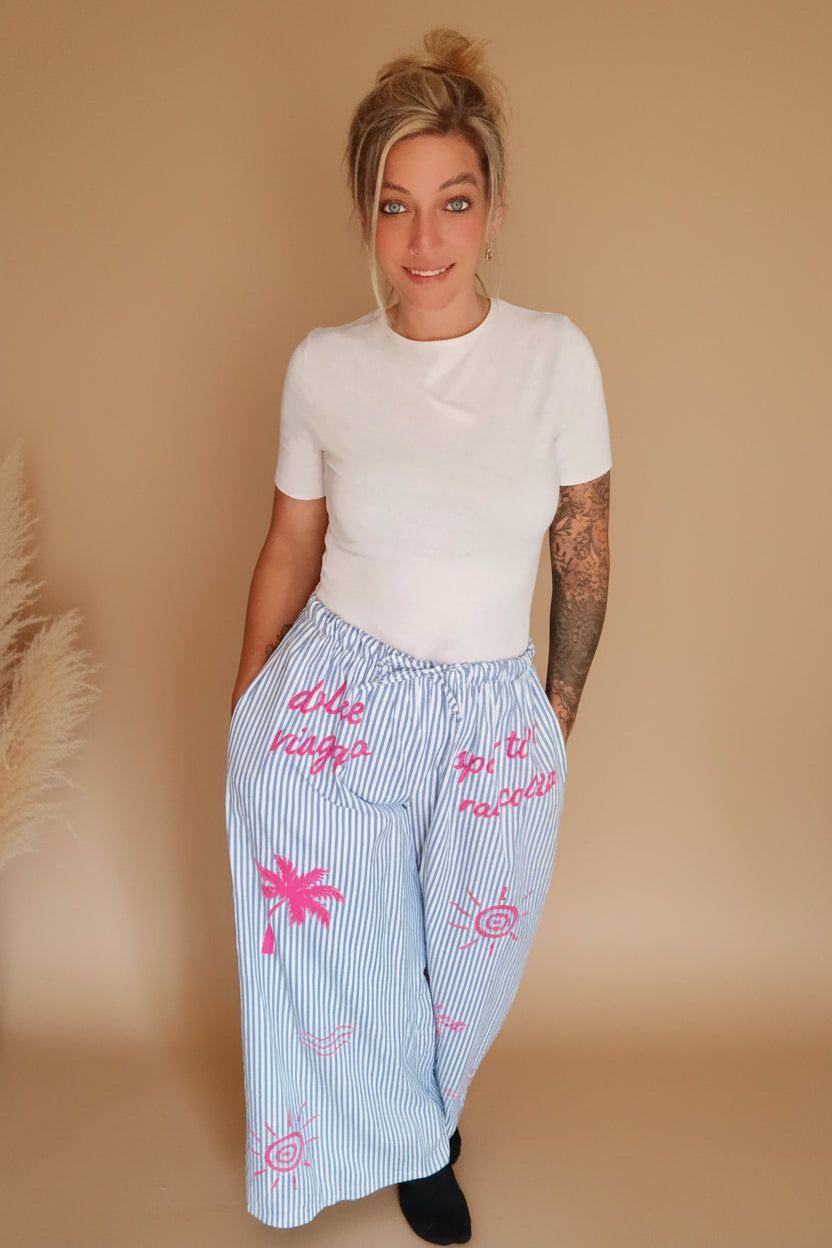 Boho-Luxe blau-weiß gestreifte Leinenhose mit pinken tropischen Prints.