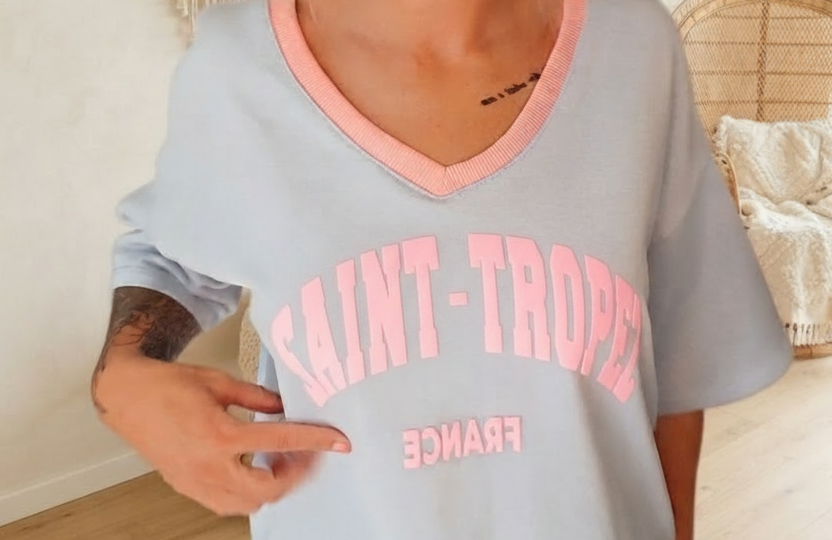 Hellblaues Boho-Luxe T-Shirt aus Baumwolle mit rosa V-Ausschnitt und Saint-Tropez Print.