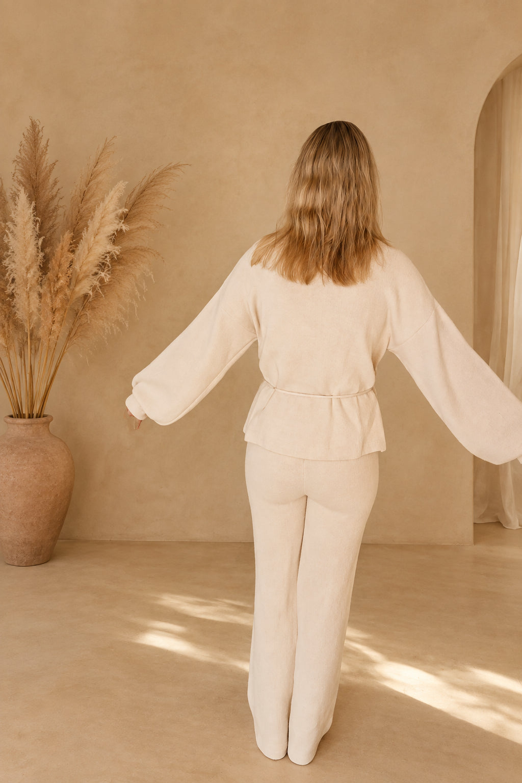 Beigefarbenes Strick-Loungewear-Set von hinten, Ganzkörperansicht mit weiter Hose