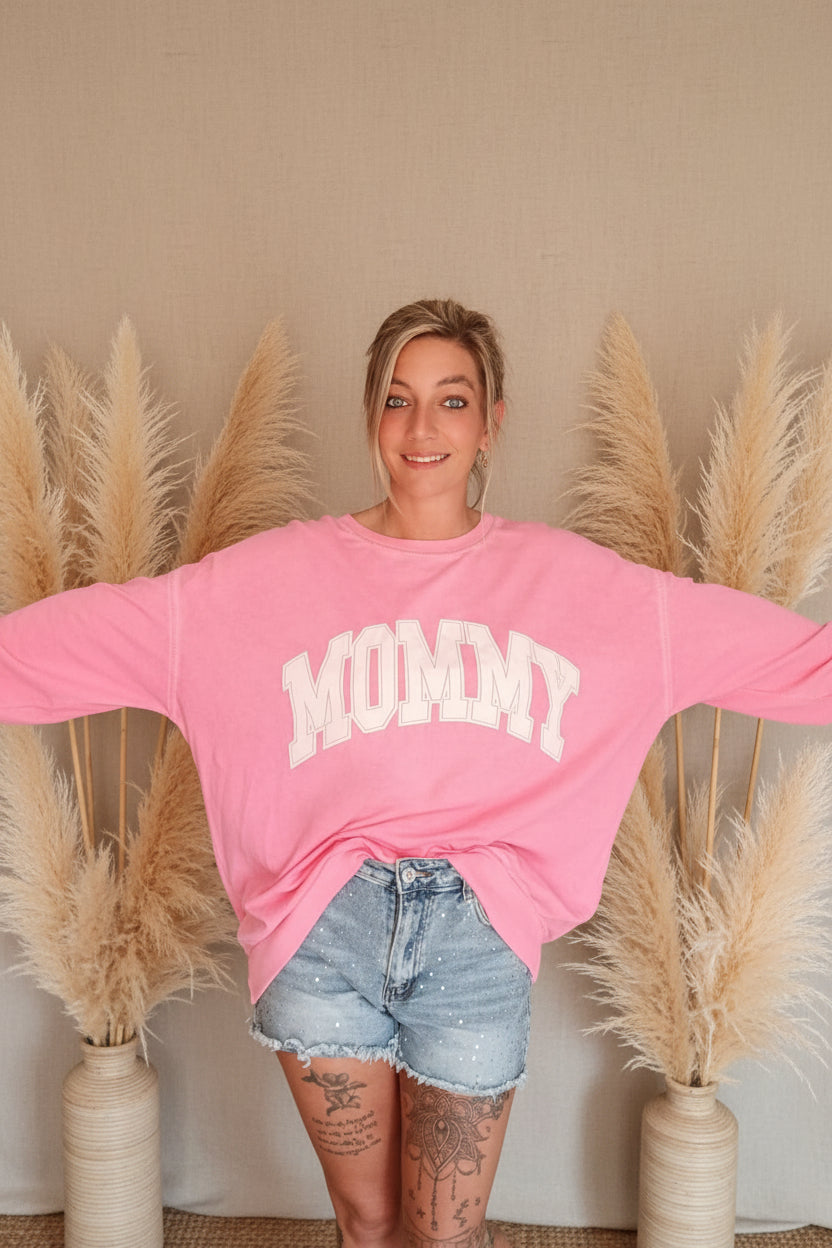Rosa Boho-Luxe Damen-Sweatshirt mit weißem Mommy-Print und hellblauen Jeans-Shorts.