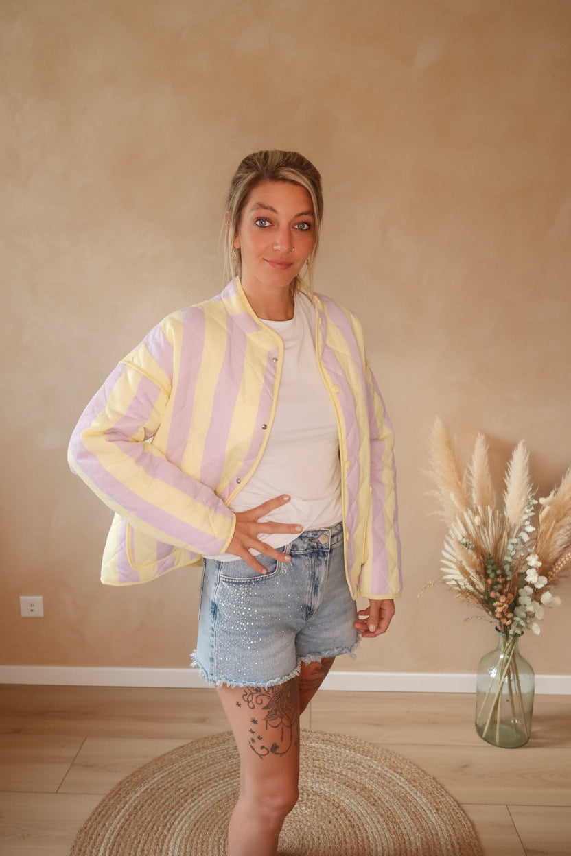 Boho-Luxe gesteppte Jacke in Gelb und Flieder mit weißem Shirt und Denim-Shorts.