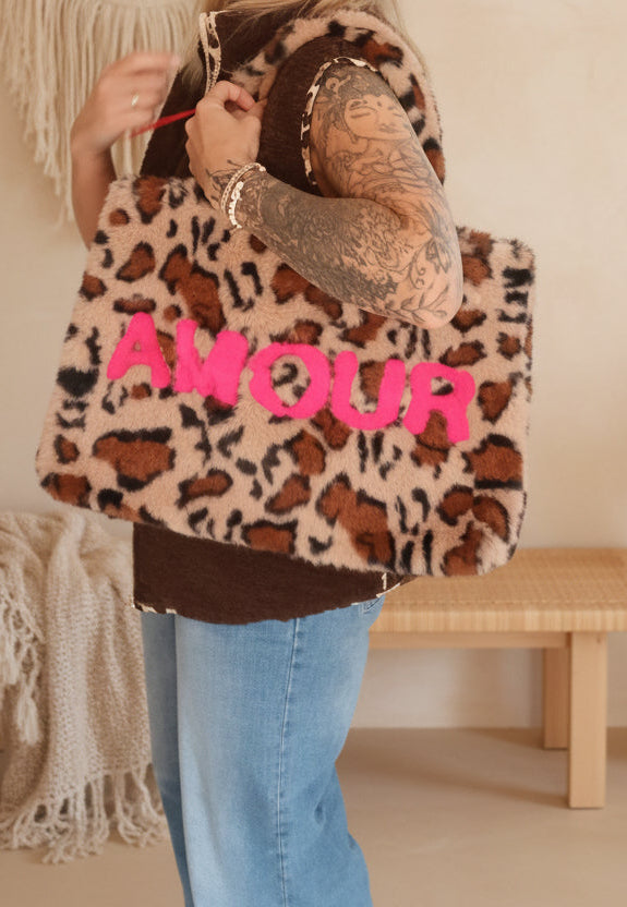 Shopper Happy Leo Beige – Lifestyle-Shot mit Leo-Shopper über der Schulter, warmer Boho-Hintergrund