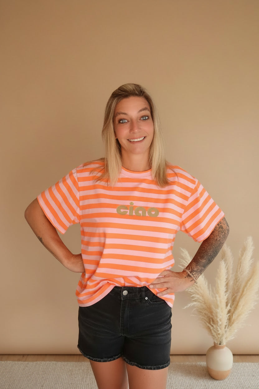 Boho-Luxe Look: Gestreiftes T-Shirt in Orange und Rosa aus Baumwolle mit schwarzer Shorts.