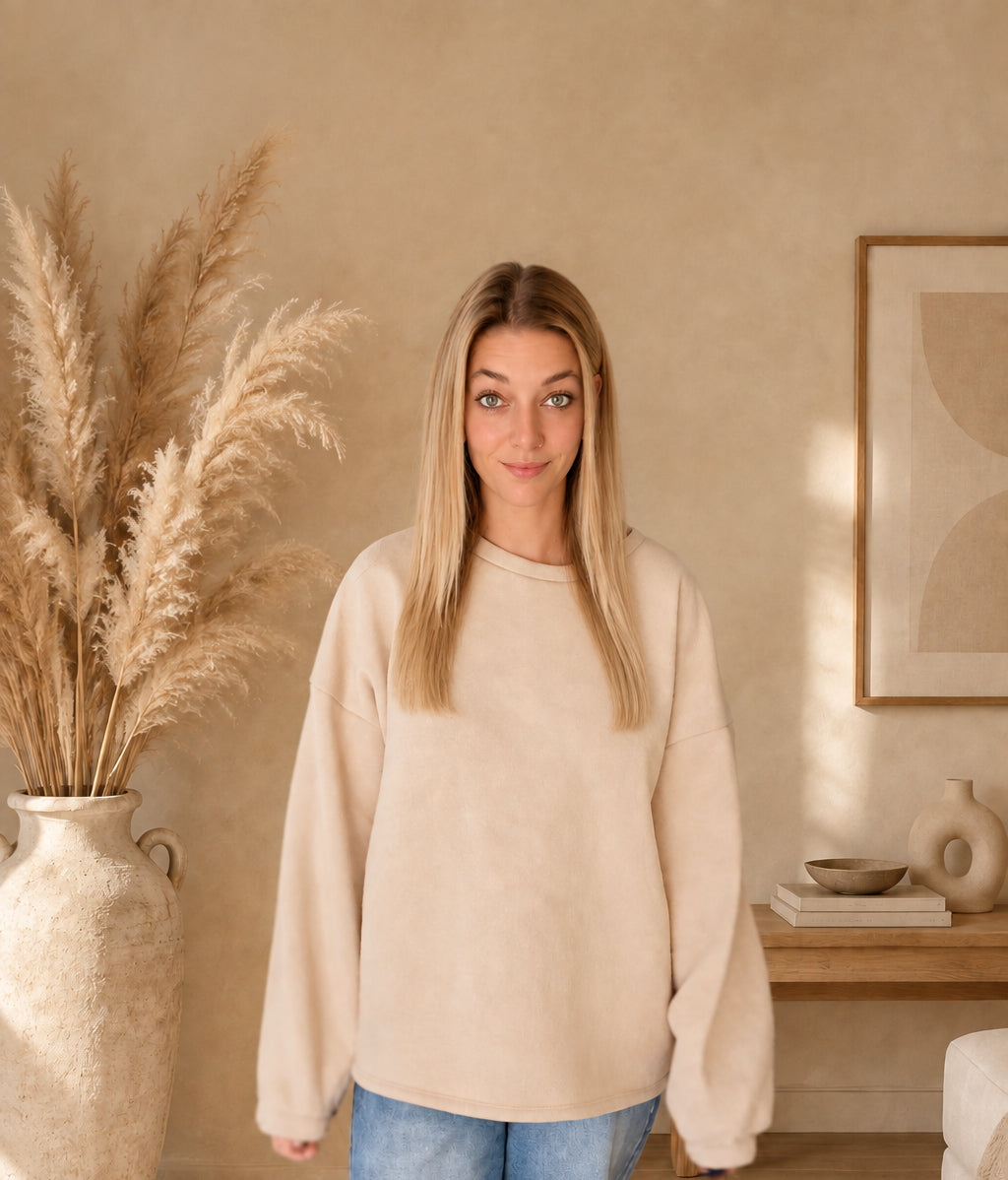 Damen-Sweatshirt in Creme mit Rundhalsausschnitt, überschnittenen Schultern und langen Ärmeln, frontal am Model.