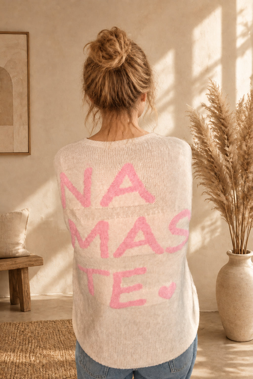 Cremeweißer Namasté-Pullover von hinten mit rosa Schriftzug und Herz.

